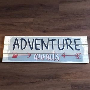 “Adventure Awaits” sign